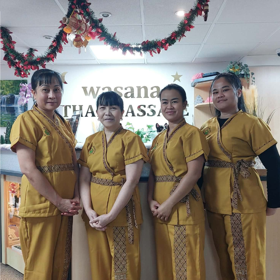 Mitarbeiterinnen Wasana Vier Mitarbeiterinnen stehen vor dem Empfangstresen bei Wasana Thai Massage